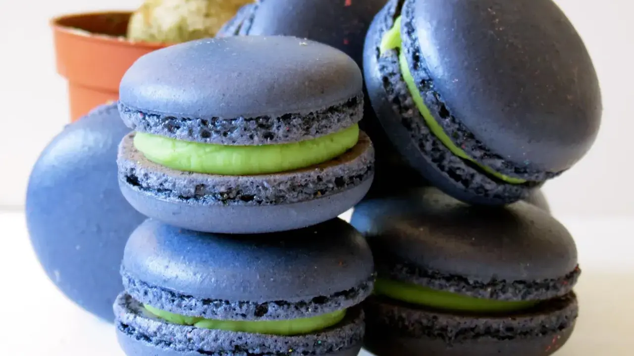 Macarons bleus avec une garniture verte vibrante, parfaits pour une recette macaron pistache.