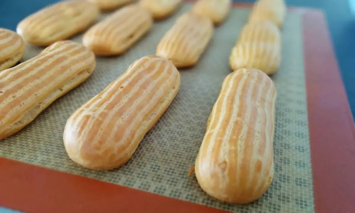 Des éclairs dorés prêts pour garnir, issus d'une recette pâte à choux éclair réussie.