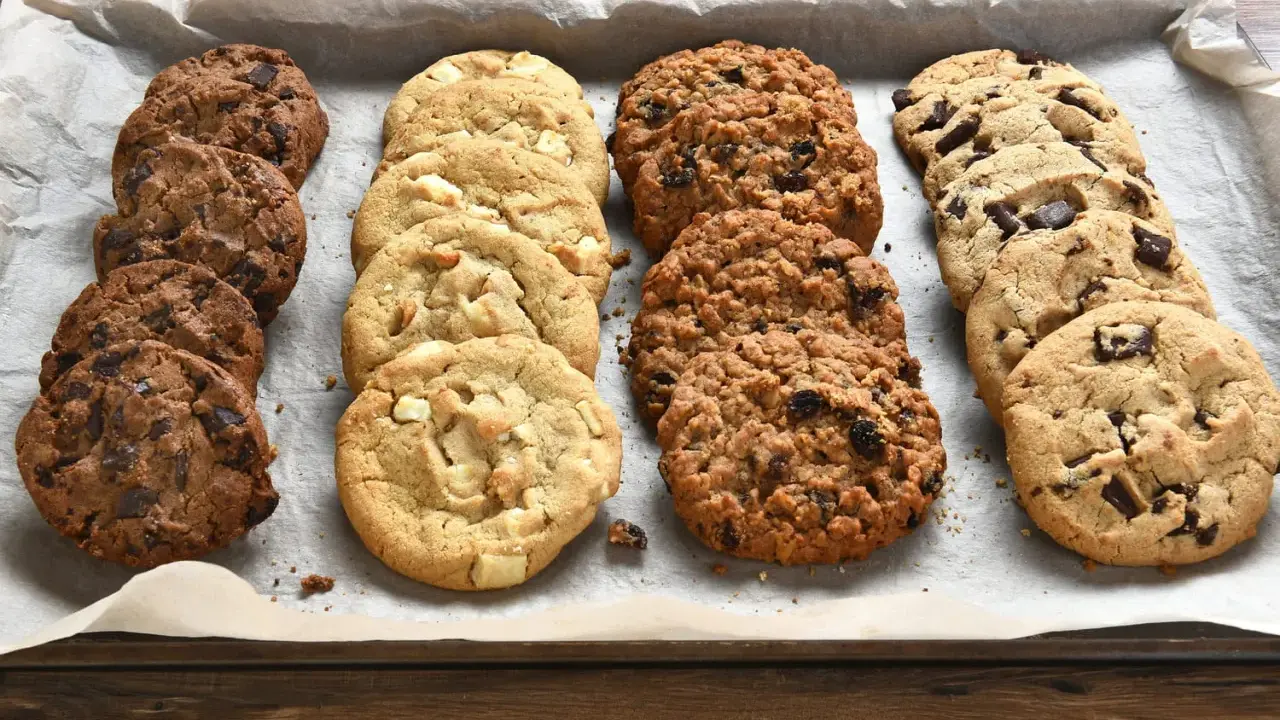 Une variété de biscuits moelleux, aux pépites de chocolat, blancs et aux flocons d'avoine, prêts à être dégustés. Parfait pour une recette facile.