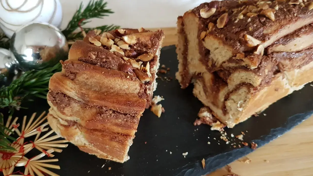Délicieuse babka recette, un gâteau tressé au chocolat et noisettes, orné de décorations de Noël.