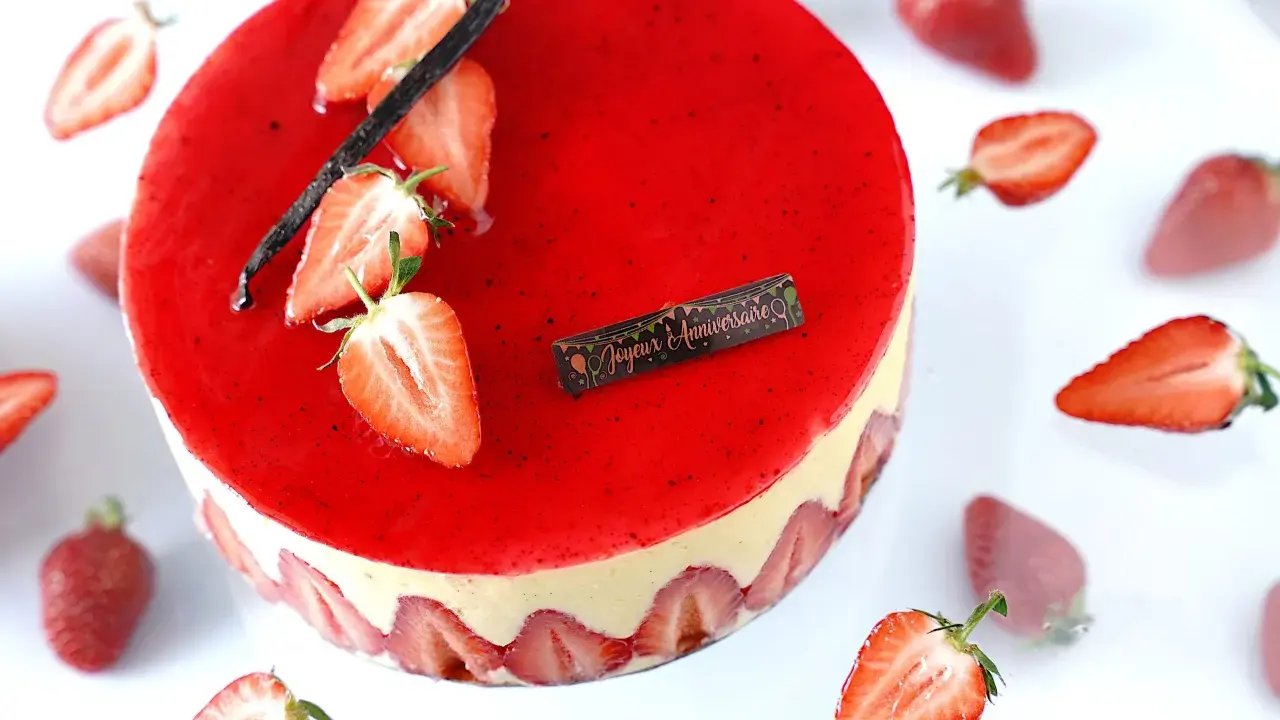 Gâteau fraisier à la crème mousseline, décoré de fraises fraîches et d'une gousse de vanille. Parfait pour une recette d'anniversaire.