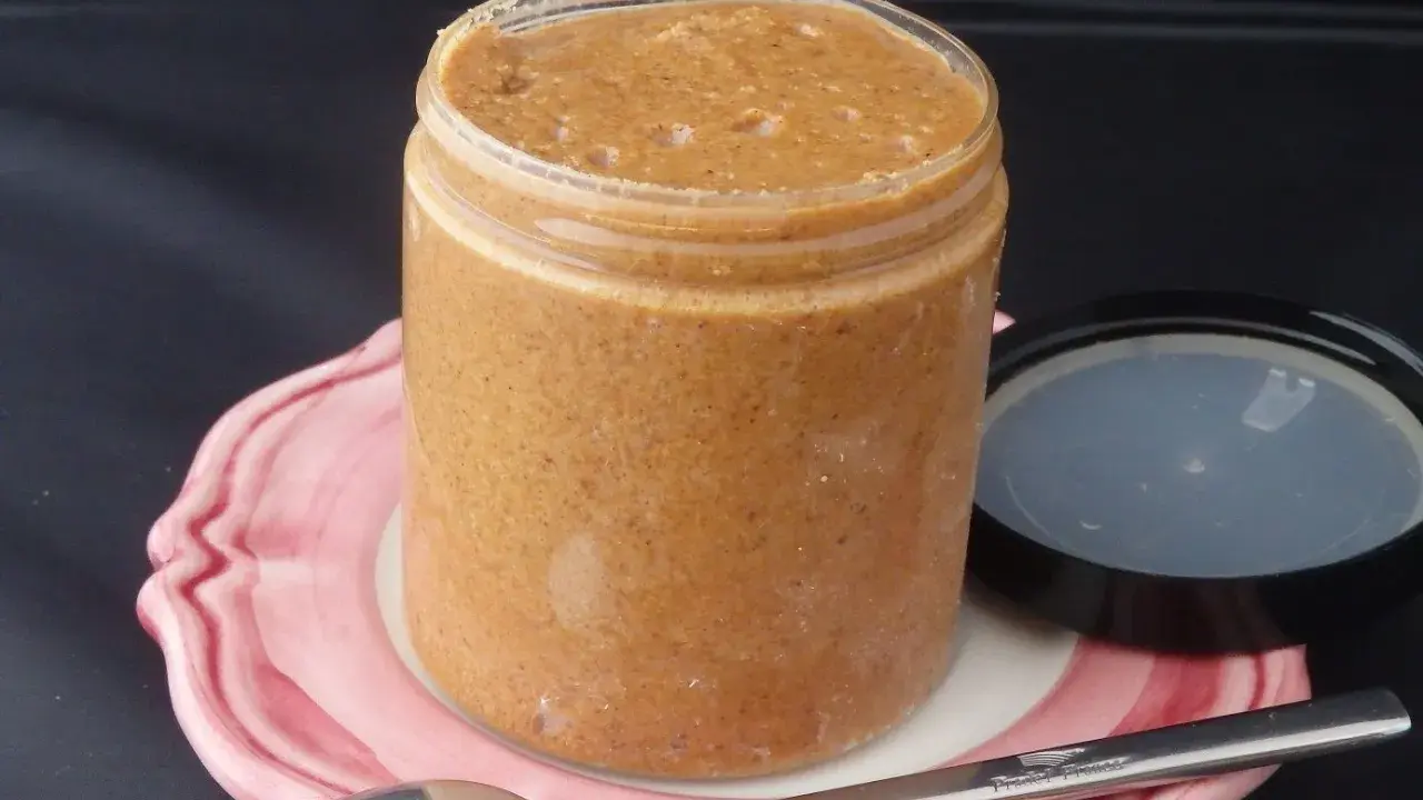 Un pot de praliné maison, onctueux et gourmand, prêt à être dégusté avec une cuillère.