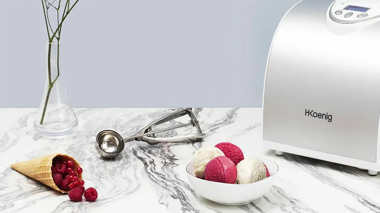 La turbine à glace Koenig HF340 prépare de délicieuses glaces maison. Une cuillère à glace et des fruits rouges complètent la scène.
