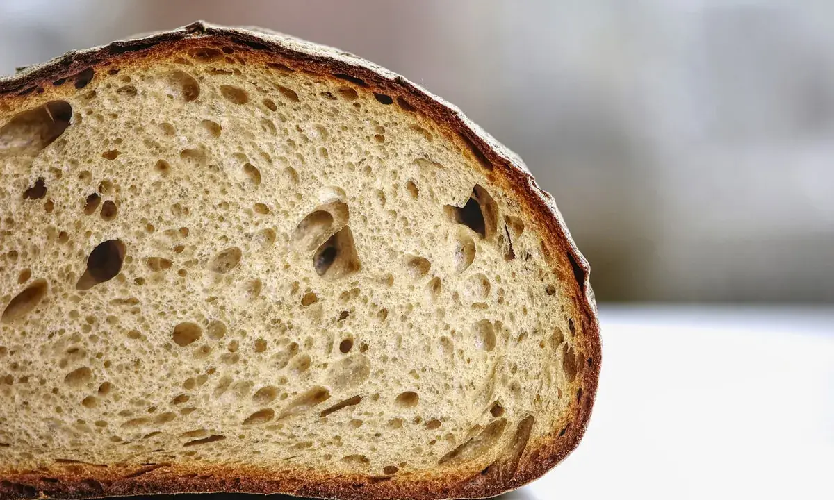 Tranche de pain artisanal à la mie aérée et à la croûte dorée. Pour savoir comment conserver le pain, il faut le garder à température ambiante.