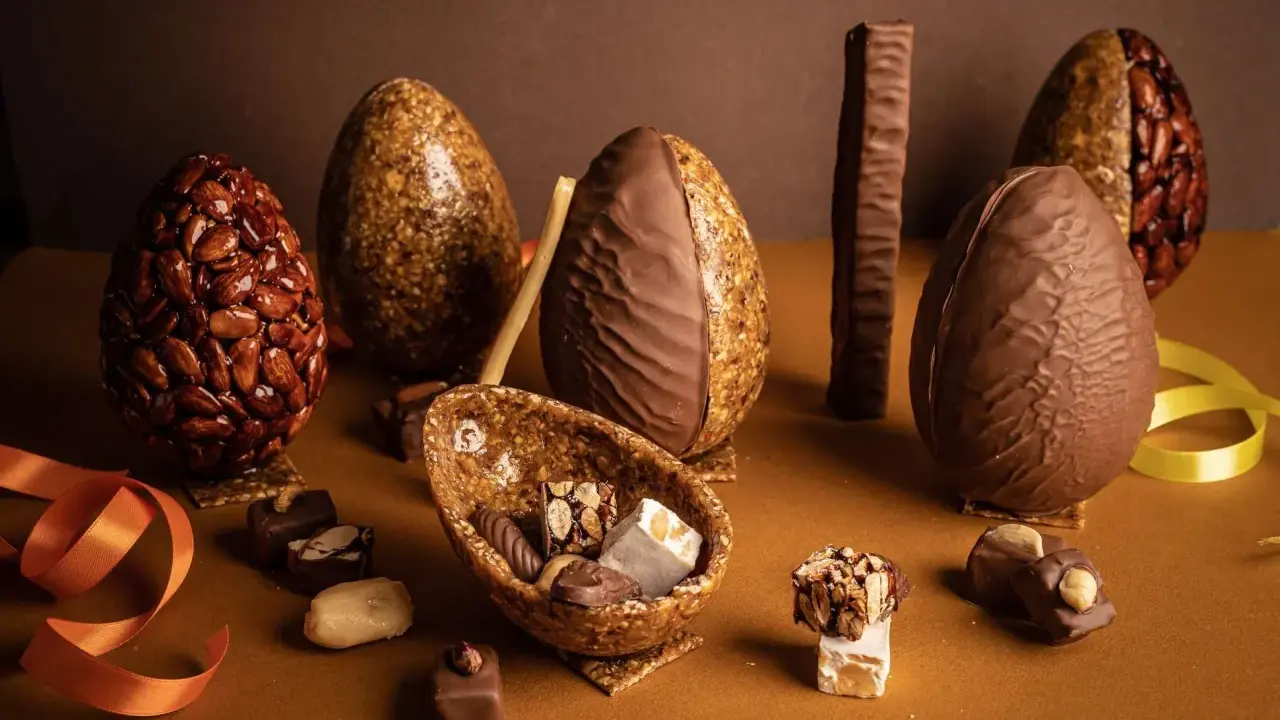 Œufs en chocolat et nougatine, certains décorés d'amandes croquantes. Une composition gourmande pour Pâques.