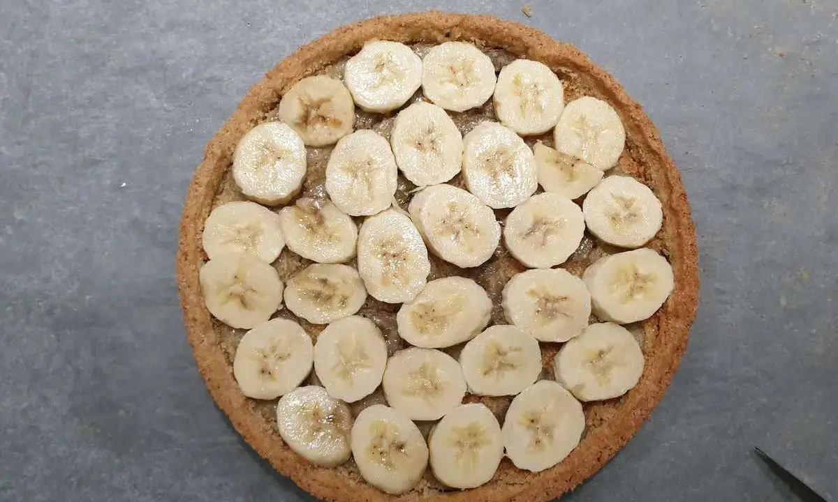 Tarte banoffee origine : rondelle de bananes sur une pâte sablée, prête à être dégustée.