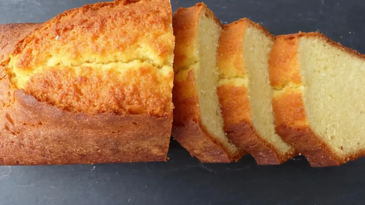 Un quatre-quarts breton, doré et moelleux, coupé en tranches sur fond sombre. Parfait pour une recette simple et gourmande.