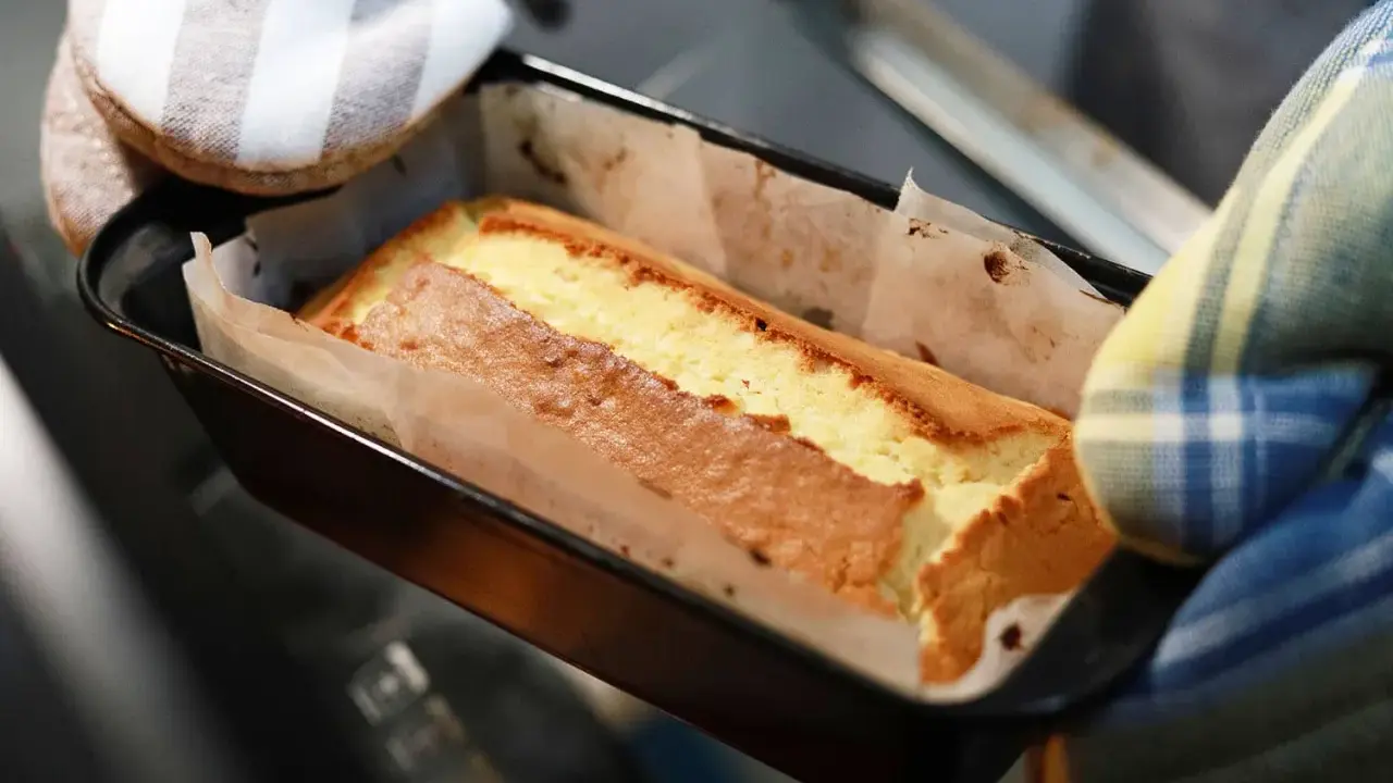 Un gâteau doré sort du four, sa pâte à gâteau parfaitement cuite dans son moule.