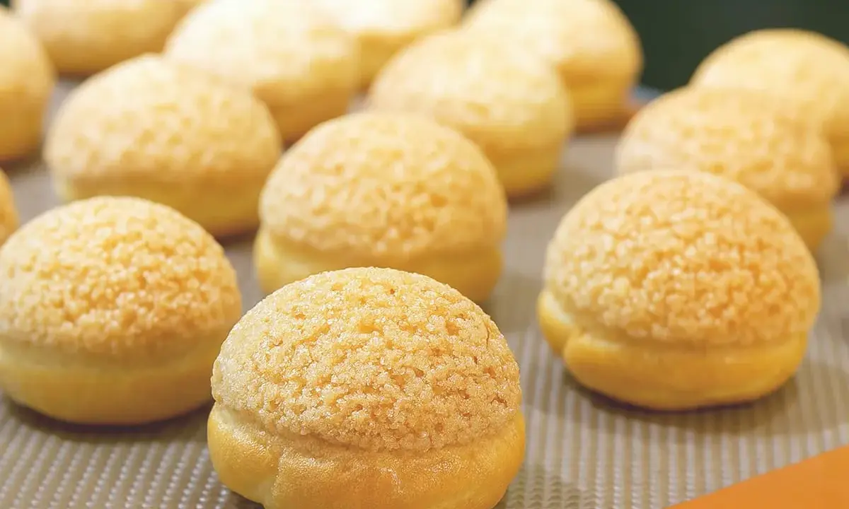 Une rangée de craquelins choux dorés et croustillants, prêts à être dégustés.