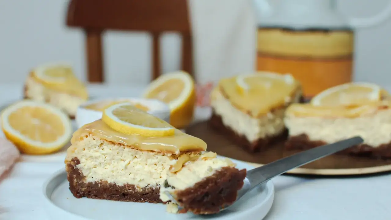 Tranches de cheesecake citron, garnies de rondelles de citron frais, sur une assiette blanche.