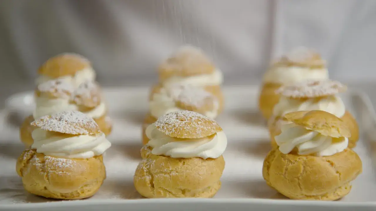 Petits choux garnis de crème fouettée, saupoudrés de sucre glace. La cuisson des choux est parfaite, dorée et légère.