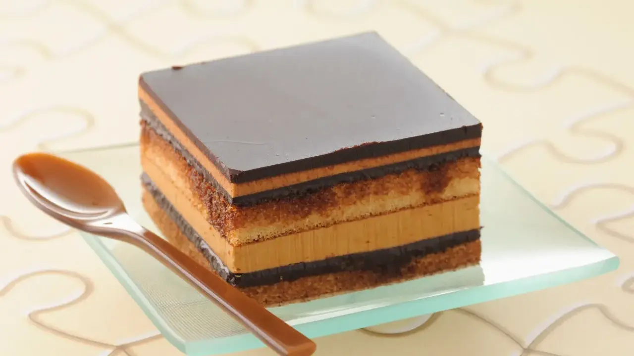 Un délicieux gâteau Opéra, une recette facile à réaliser, avec ses couches de biscuit, de crème au café et de ganache au chocolat.