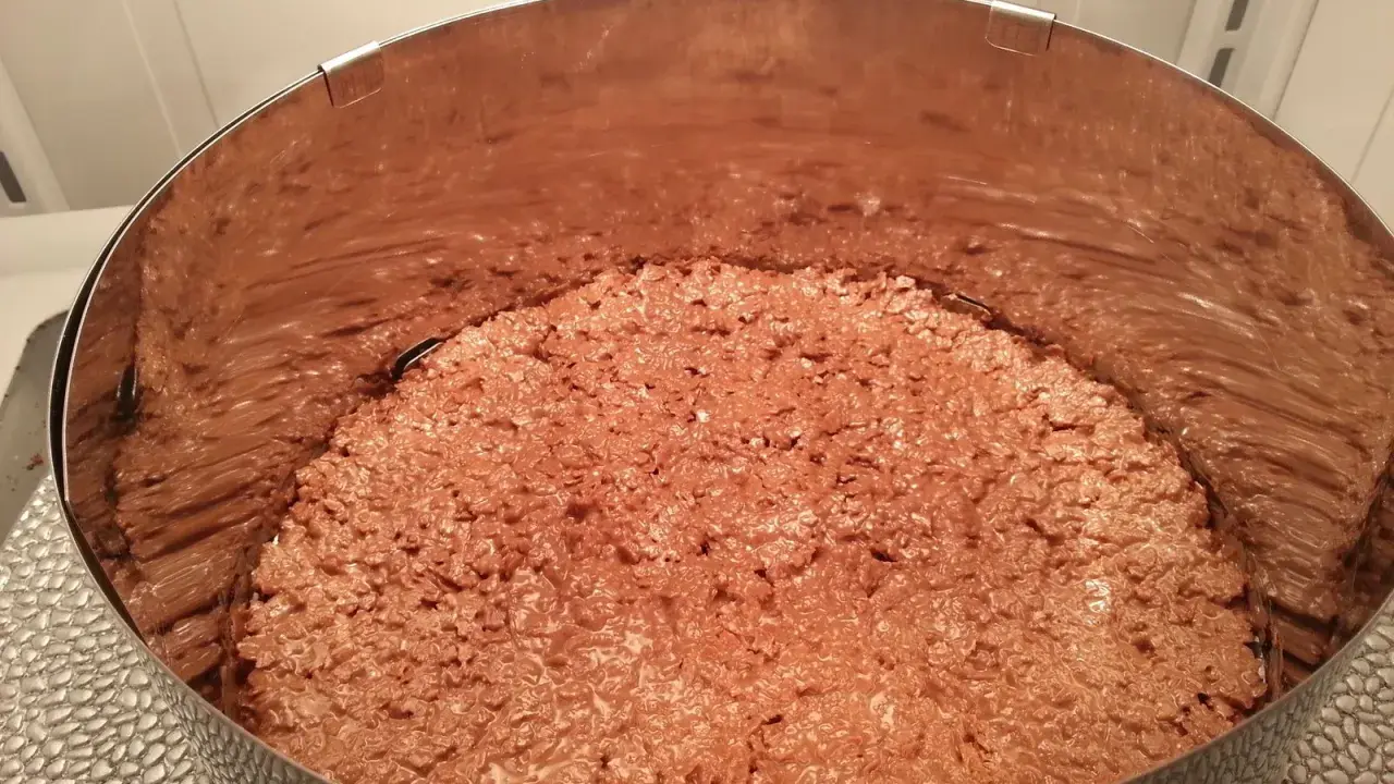 Fond de gâteau croustillant sans cuisson, une texture gourmande de chocolat et de riz soufflé dans un cercle à pâtisserie.