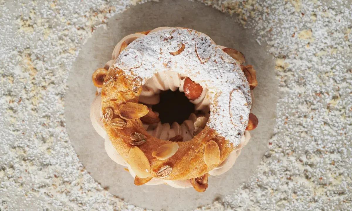 Un Paris-Brest aérien, garni d'une crème onctueuse et décoré d'amandes effilées. Le praliné pour Paris-Brest est ici sublimé.