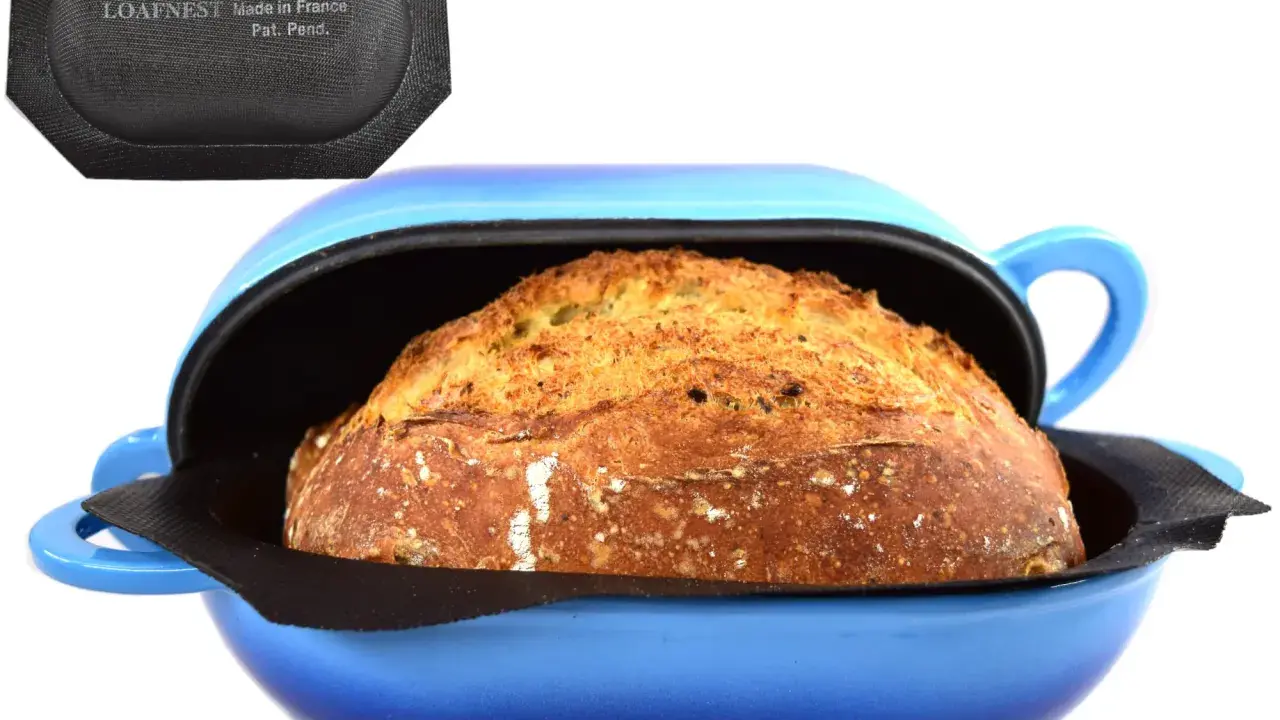 Pain doré dans une cocotte bleue, prêt pour la cuisson. Le couvercle noir avec "LOAFNEST" suggère une cuisson parfaite, chaleur tournante ou pas.