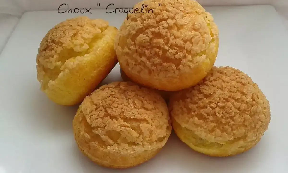 Quatre choux craquelin dorés et croustillants, prêts à être garnir.