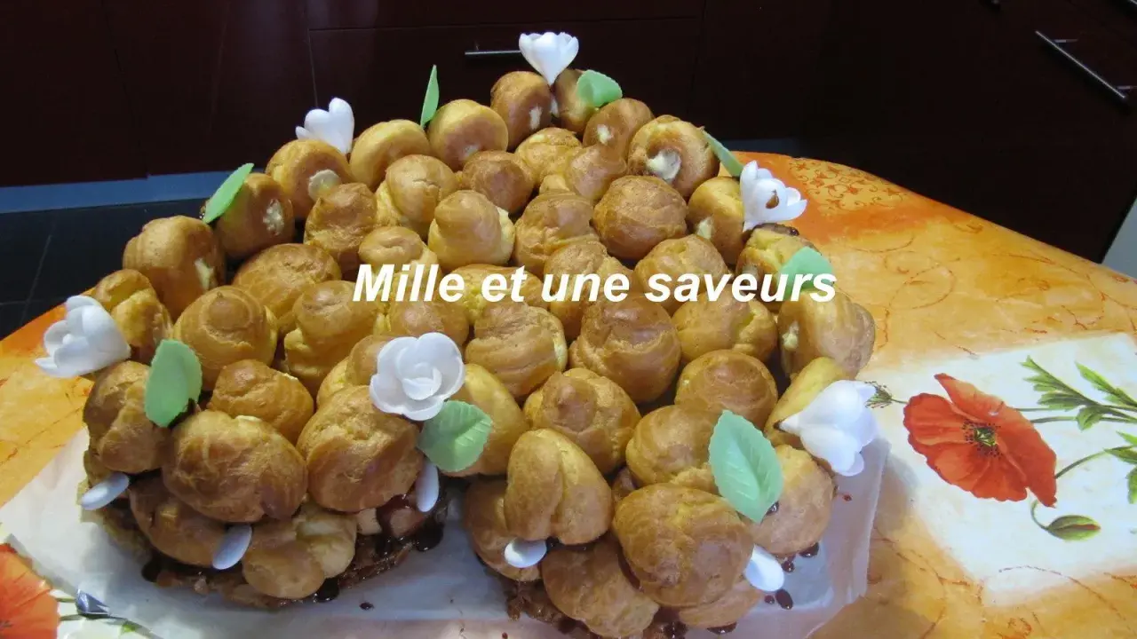 Magnifique chou pièce montée, un délice pour les yeux et les papilles, ornée de fleurs blanches et de feuilles vertes.
