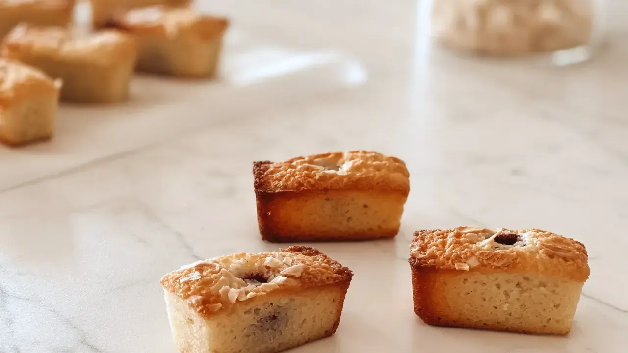 Financiers dorés, parfaits après une cuisson à chaleur tournante. Ils sont garnis de fruits et de noix de coco râpée.