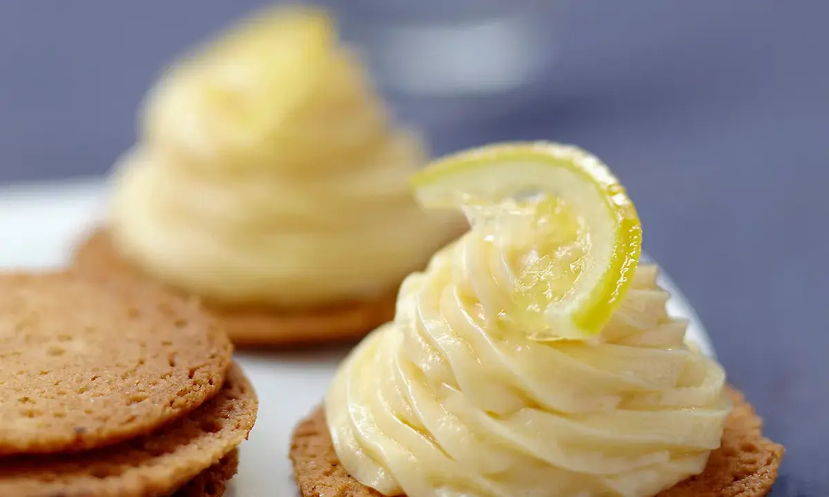 Deux petits gâteaux sur des biscuits sablés, ornés d'une délicieuse crème pâtissière citron et d'une fine tranche de citron.