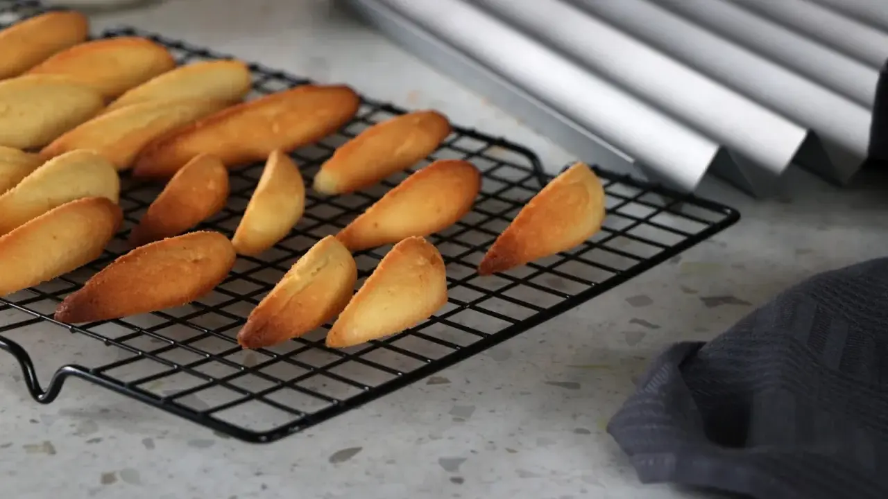 Biscuits dorés en forme de dent de loup refroidissent sur une grille.
