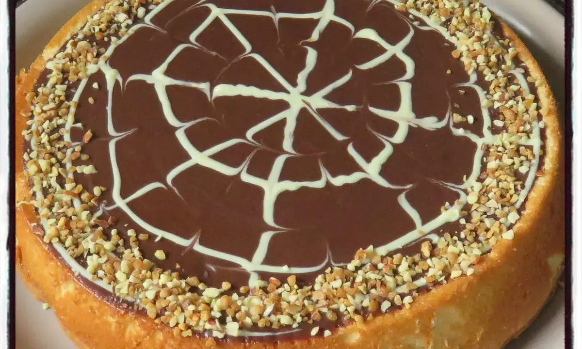 Gâteau génoise chocolat, ganache onctueuse, décor de chocolat blanc et éclats de noisettes. Un délice !