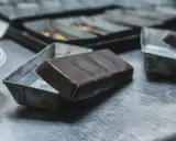Une tablette de chocolat posée sur une petite boîte métallique. Idéal pour apprendre comment faire des copeaux de chocolat.