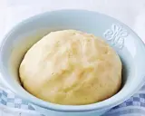 Pâte sablée prête pour la cuisson, dans un bol bleu clair. Une texture parfaite pour des tartes croustillantes.