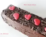 Bûche chocolat passion, un délice chocolaté orné de copeaux de chocolat et de cœurs rouges.