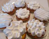 Assortiment de tartelettes garnies d'une crème citron et surmontées de **meringue italienne** aux formes variées.