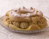 Un Paris-Brest généreusement garni de crème pâtissière au caramel beurre salé, saupoudré de sucre glace et d'amandes effilées.