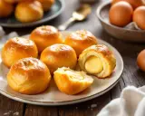 Petits pains dorés, certains coupés révèlent une garniture crémeuse. Ces douceurs rappellent la pâte à choux des éclairs.