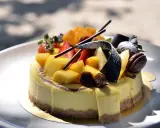 Gâteau crémeux sur un fond biscuit pour gâteau, garni de mangues, fraises, figues et chocolat.