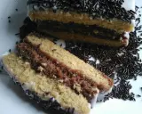 Délicieux napolitain maison, avec ses couches de génoise et de chocolat, nappé de glaçage blanc et saupoudré de vermicelles.