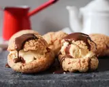 Délicieux profiteroles chocolat, garnis de glace et nappés de sauce au chocolat, prêts à être dégustés.