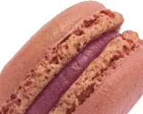 Un délicieux macaron framboise, avec sa coque rose pâle et sa ganache violette intense.
