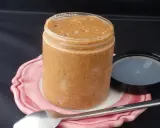 Un pot de praliné maison, onctueux et gourmand, prêt à être dégusté avec une cuillère.