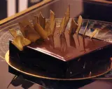 Gâteau royal chocolat Michalak, un délice glacé aux éclats dorés, prêt à être dégusté.