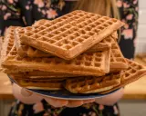 Une pile de gaufres dorées, prêtes à être dégustées. La pâte à gaufres a été cuite à la perfection, créant une texture croustillante à l'extérieur et moelleuse à l'intérieur.