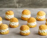 Douze petits choux garnis de crème fouettée, parfaits pour une recette pâte à choux professionnel.