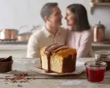 Un couple partage un moment tendre en cuisine, devant un gâteau marbré arrosé de chocolat. Une recette barquette chocolat parfaite pour un moment gourmand.
