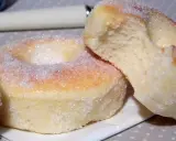 Deux beignets au four, saupoudrés de sucre, dont l'un est coupé, révélant une mie moelleuse.