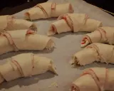 Huit croissants garnis de jambon et de fromage, prêts à être cuits. Une délicieuse pâte à pâte pour un en-cas savoureux.