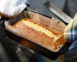 Un gâteau doré sort du four, sa pâte à gâteau parfaitement cuite dans son moule.