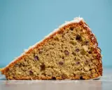 Tranche de gâteau au froment, parsemée de pépites de chocolat, avec un glaçage blanc. Un délice !