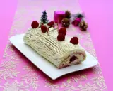 Bûche de Noël au chocolat blanc et framboise, décorée de fruits rouges et d'un petit sapin. Une délicieuse recette pour les fêtes.