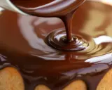 Un glaçage chocolat caramel coule sur un gâteau. La texture lisse et brillante promet un délice gourmand.