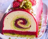 Bûche de Noël aux pistaches et framboises, un délice visuel et gustatif. La recette buche pistache framboise parfaite pour les fêtes.