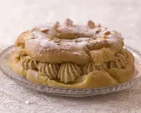 Bûche façon Paris-Brest, une couronne de pâte à choux garnie de crème onctueuse et saupoudrée de sucre glace et d'amandes effilées.