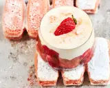 Un délicieux tiramisu aux biscuits roses de Reims, garni de fraises et de crème onctueuse, sur un lit de biscuits saupoudrés de sucre glace.