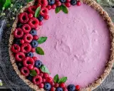 Délicieuse tarte aux fruits avec une garniture rose et des framboises, myrtilles et groseilles. La décoration tarte aux fruits est simple et élégante.